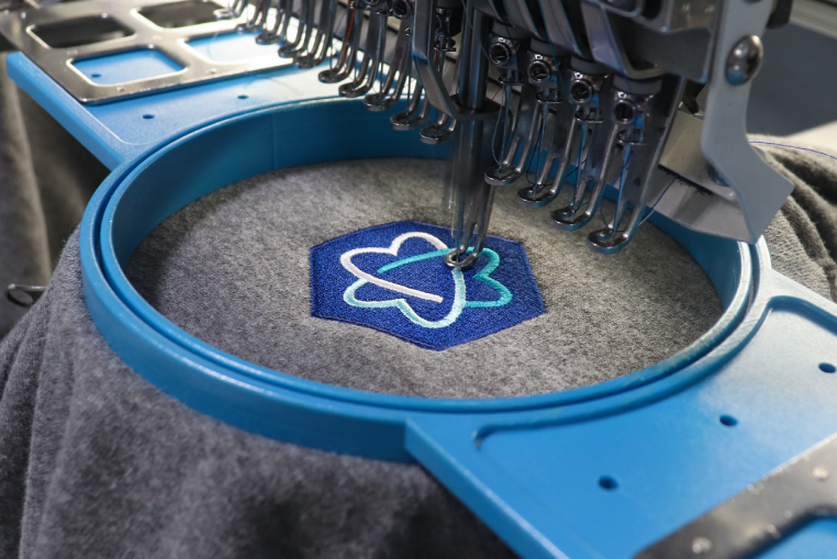 Custom logo embroidery stitching on a custom company polo shirt - Merchology